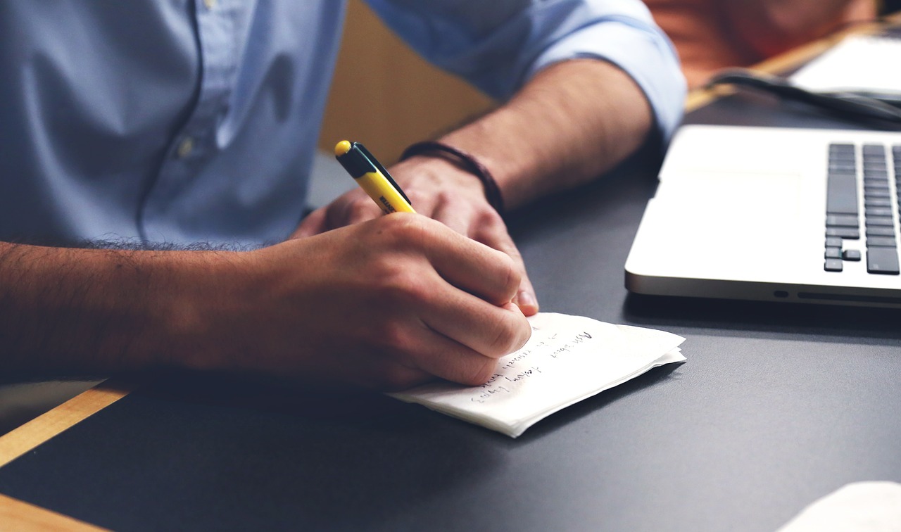 man writing on paper