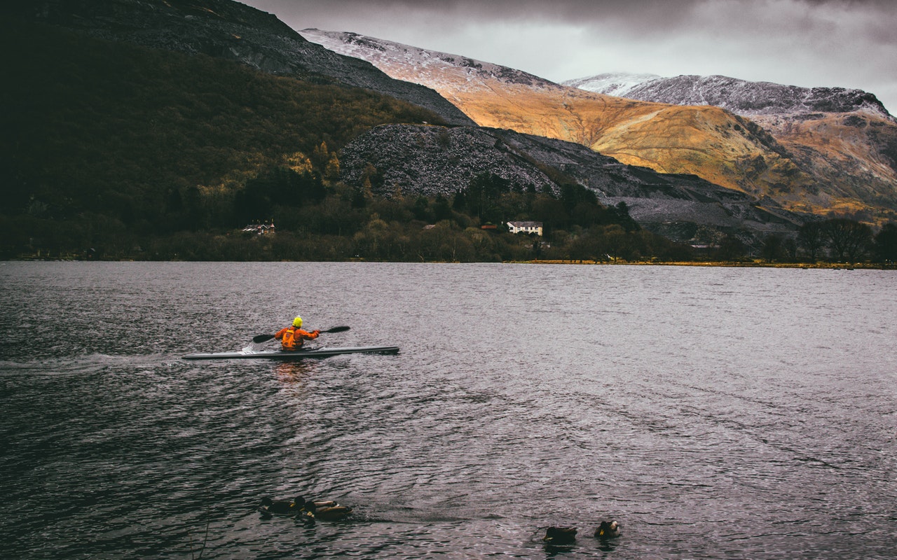 a small kayak in the middle of large lake